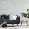 Patterned cushions on sofa next to wooden table and plant in dar MERCURY STONE BLUE